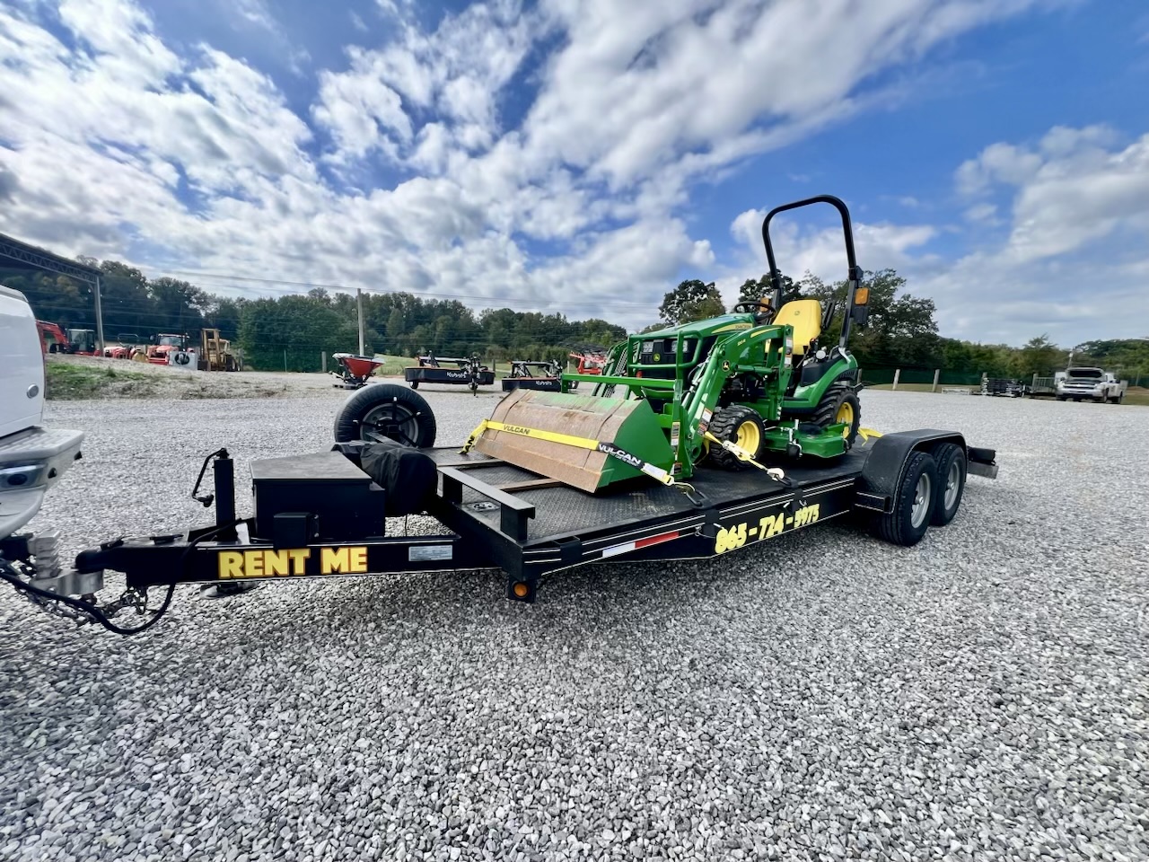 Green John Deere tractor with loader on Trailblazer car hauler trailer - professional equipment transport